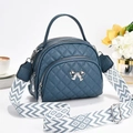 Navy quilted crossbody bag with silver bow detail and stylish wavy wide strap - Blue