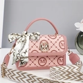 Detailed shot of pink monogram crossbody bag with golden M lock and decorative silk scarf - Pink