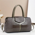 Sac à main vert grisâtre avec gaufrage crocodile et bandoulière dans un décor épuré - Gris