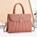 Detail of lychee pattern leather handbag with gold metal lock and pleated design - Pink