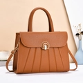 Dettaglio della borsa tote in pelle color cuoio con trama a pieghe e fibbia dorata - Giallo Terra