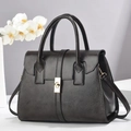 Detail view of black polished leather handbag with gold hardware and removable shoulder strap - Gray / 29x14x22
