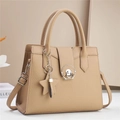 Beige pebbled leather handbag with round metal buckle and star charm accessory - Khaki