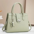 Detail of light green pebbled leather handbag with silver lock and star charm decoration - Green