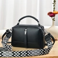 Minimalist black lychee texture square shoulder bag with wide geometric strap on wood desk - Black