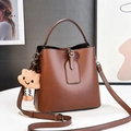 Brown leather bucket bag with top handle, crossbody strap, and plush cloud charm detail - L19 W12 H19 / Khaki/Earth Yellow
