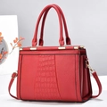 Détail du sac cabas rouge avec cuir à motif crocodile et garnitures en métal doré - Bordeaux