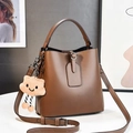 Brown bucket bag details with plush cloud charm and adjustable leather shoulder strap - L19 W12 H19 / Brown