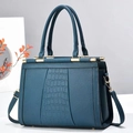 Close-up of navy blue faux leather tote with lychee and crocodile texture and gold hardware - Blue