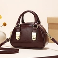 Detail of burgundy mini bowling bag with glossy wrinkled texture and gold buckles - Brown