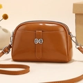 Brown semi-circular faux leather crossbody bag with silver bow accent and adjustable strap - Earthy Yellow