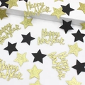 Macro detail of Happy New Year confetti with gold glitter stars and black star cutouts - Black Gold Star and Gold Glitter Happy New Year Confetti