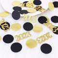 Close-up of glitter gold 2023 number and black round confetti on white faux fur - Black Gold Card Circle and Gold Card 2026 Confetti