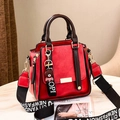 Detalle de bolso de cuero PU rojo con asas marrones y llavero de oso decorativo incluido - Largo 21 Ancho 11 Alto 21 / Burdeos