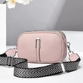 Detail view of pink leather crossbody bag with three zippers and woven strap on stone - 21*8*14 / Pink