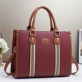 Deep red tote bag with brown handles and striped ribbon detail, 45-degree front view - Red