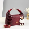 Dettaglio della mini borsa bordeaux con trama a coccodrillo, fibbie dorate e ciondolo - Rosso Vino