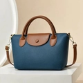 Close-up of pebble leather texture and elegant contrast stitching on crossbody bag - Blue