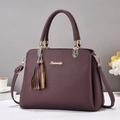 Deep purple lychee grain leather handbag with gold metal accents and tassel pendant - Purple