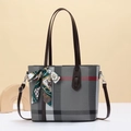 Detail of classic plaid tote bag with dark brown leather handles and silk scarf accent - Gray