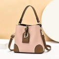 Detail of pink and brown leather bucket bag featuring a gold metal letter D pendant - Pink
