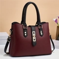 Macro detail of wine red lychee textured leather bag with black contrast strap and gold lock - Wine Red