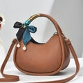 Detailed view of brown lychee grain mini handbag featuring a silk scarf handle and pearl charm - Khaki/Earth Yellow