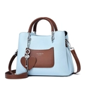 Elegante borsa a mano in pelle azzurra con manici marroni e ciondolo a cuore su bianco - Celeste