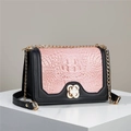 Detail of pink crocodile texture flap and golden petal buckle on black crossbody bag - Pink