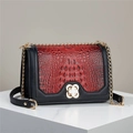 Detail of red crocodile texture bag with gold clover clasp and black leather trim - Wine Red