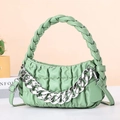 Detail of green quilted handbag featuring a chunky silver chain and woven handle - Green