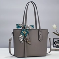 Detail of grey cross-grain leather tote bag with decorative dotted silk scarf and strap - Gray