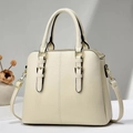 Detail view of cream-white lychee grain leather tote with gold buckles and detachable strap - Off-white