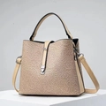 Detailed shot of beige lace bucket bag featuring leather trim and metal clasp closure - Khaki