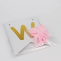 Detalle de pancarta Baby Shower con letra W dorada y cinta de seda rosa empaquetada - Welcome Baby Rosa