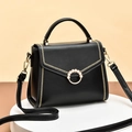 Elegant black leather tote bag with pearl gold ring and embroidery on white pedestal - Black