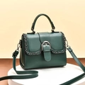 Sac à main vert foncé avec chaîne dorée et boucle métallique sur support de vente - Vert