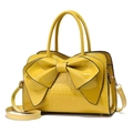 Dettaglio borsa gialla texture coccodrillo con fiocco e tracolla regolabile - Giallo