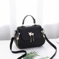 Minimalist black leather handbag for women featuring a cat pearl pendant and gold hardware - Black