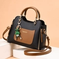 Elegante bolso de piel negro y marrón con herrajes dorados y un colgante de conejo verde - Negro