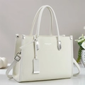 Detail view of cream leather tote bag with silver hardware and adjustable shoulder strap - Ivory
