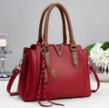 Dark red handbag with brown handles, V-shaped hardware, and woven pendant accessory - 30/12/22 / Red