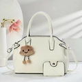 Detail of off-white lychee grain leather handbag set with plush cloud charm and silver hardware - 29x12x20cm / Off-white