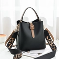 Minimalistische schwarze Beuteltasche mit braunem Griff und gemustertem Gurt - Standard / Schwarz