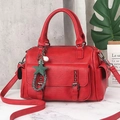 Detail of red Boston handbag with star charms on a marble floor and concrete background - Red