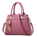 Sac à main en cuir litchi rose poudré avec motif tissé et pendentif pompon coloré - Rose