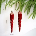 Vista detallada de los carámbanos de Navidad flocados en rojo con purpurina dorada en árbol - Estilo Carámbano