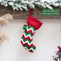 Detailopname van rood-groene gebreide kerstsok met afmetingen 40 cm x 22 cm en pompons - Golfpatroon Stijl / Rood-groen Gestreept