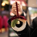 Handheld Christmas bell ornament with plush white ring, red velvet bow, and pine accent - White