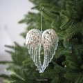 Dettaglio pendente cuore ala d'angelo in acrilico con paillettes oro champagne su albero - Ali di Angelo Trasparenti con Glitter